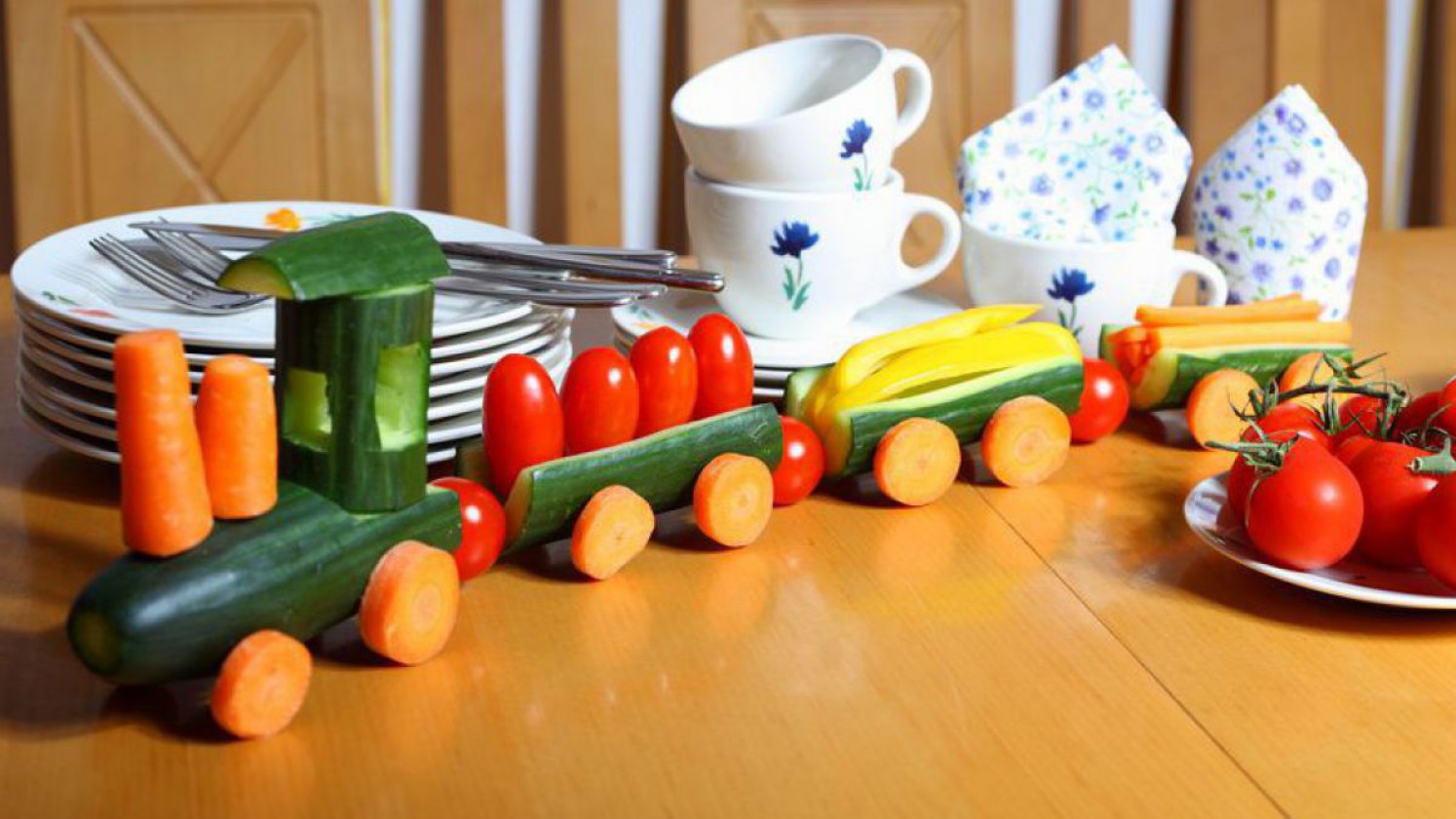 Gemüsezug aus Gurken, Tomaten und Obst gestaltet.