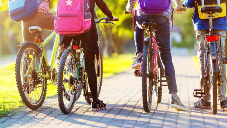 Vier Kinder auf Fahrrädern von hinten