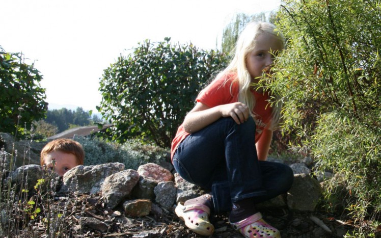 Kinder verstecken sich im Schulgarten