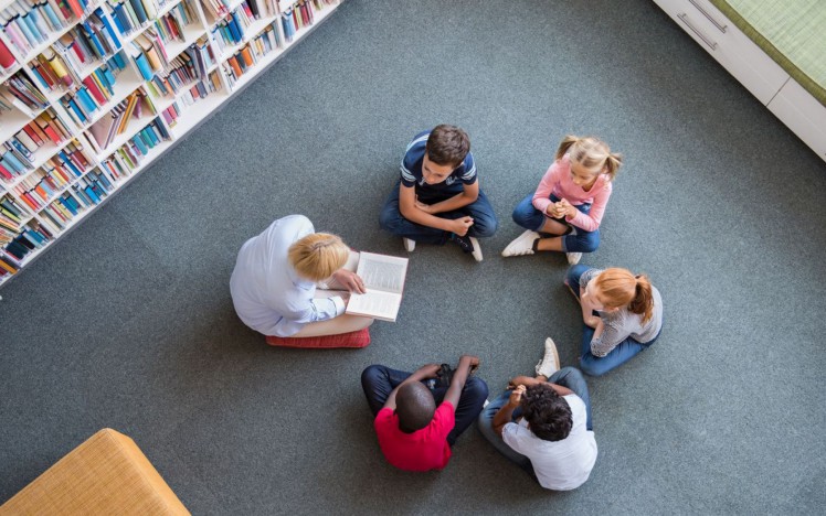 Kinder sitzen im Kreis